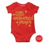 Infant dressed in a cute, patterned baby romper suit,